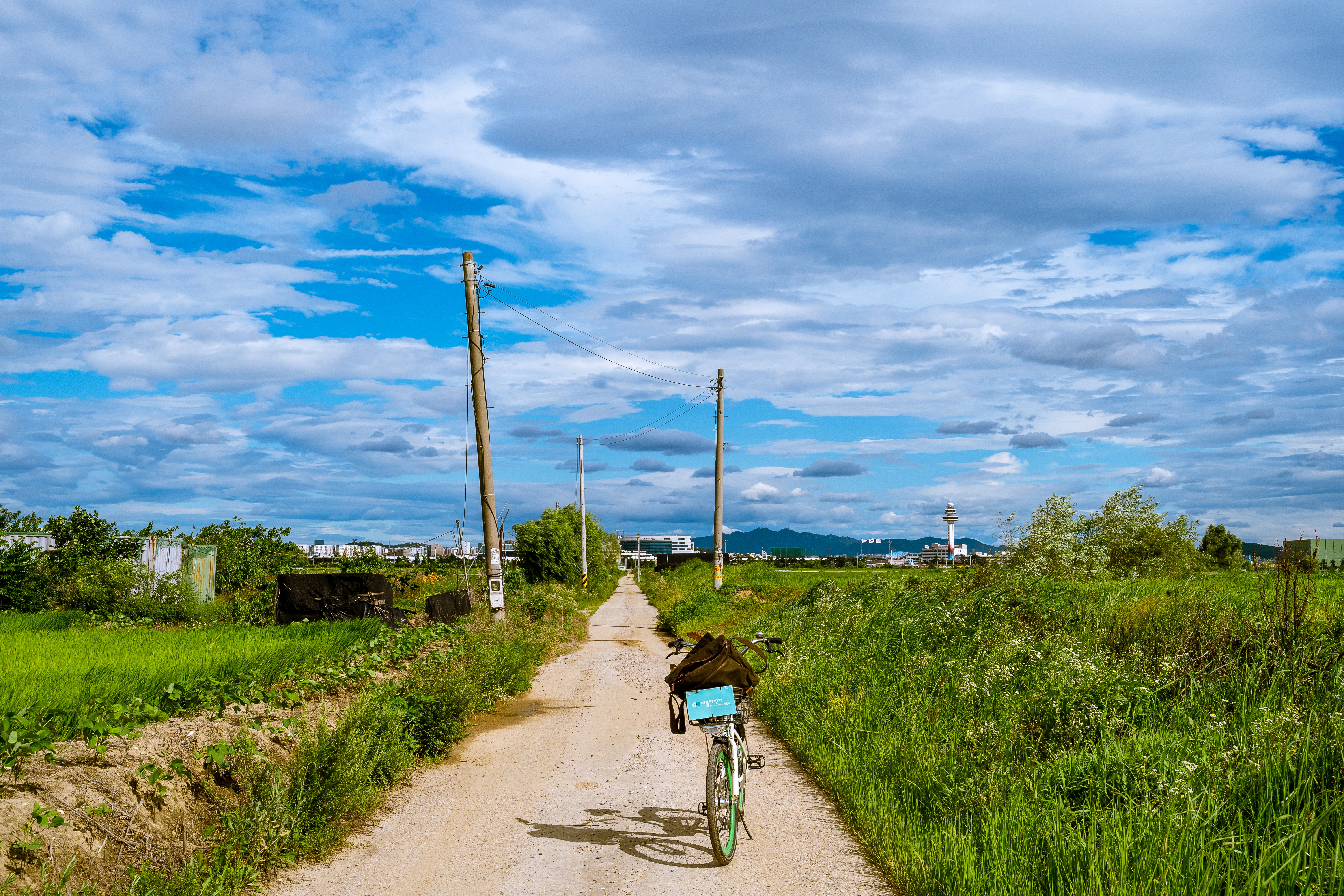 Country Road with Bicycle Under Vast Blue Skies
